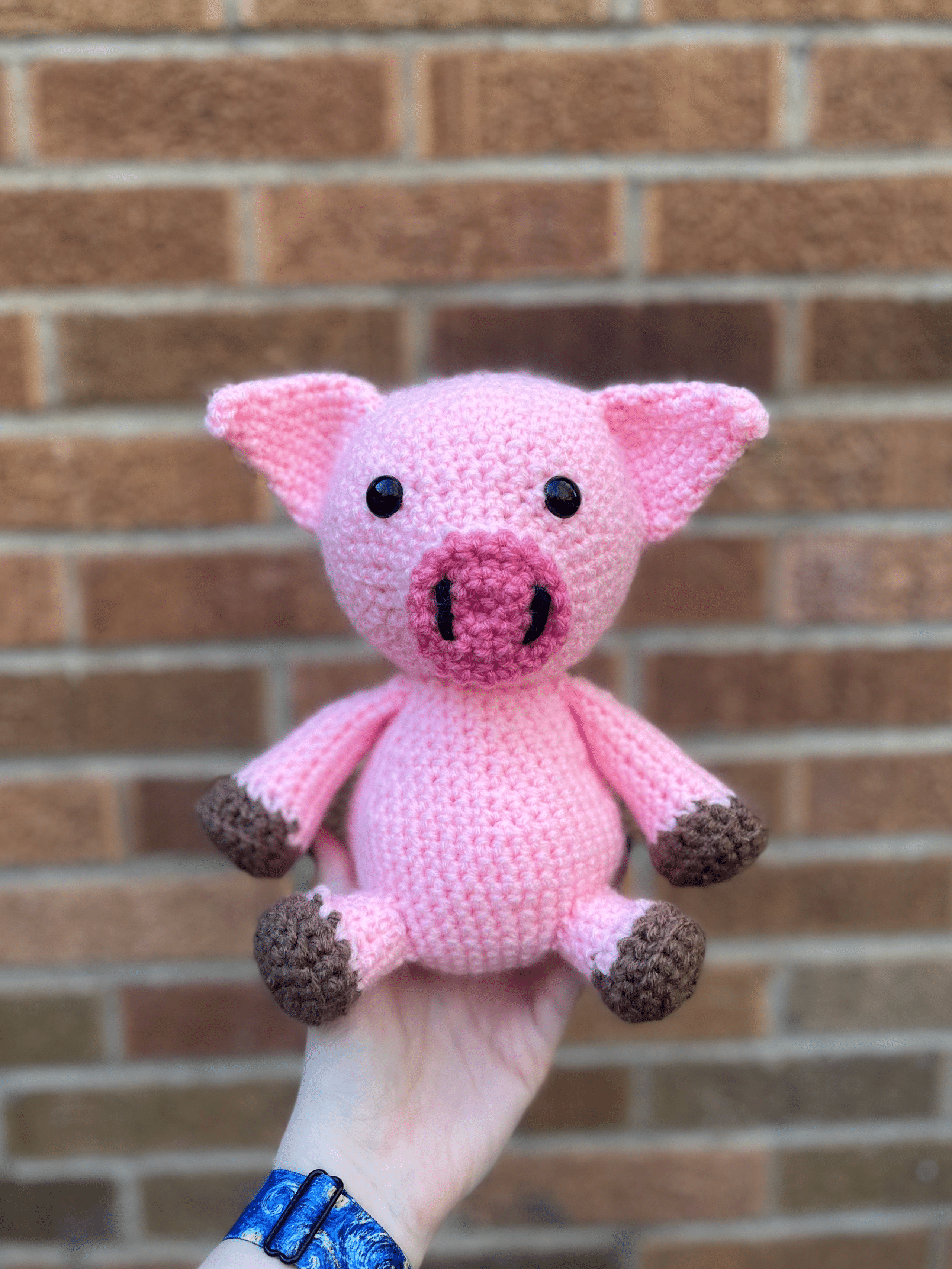 Pink Pig in front of a brick wall front