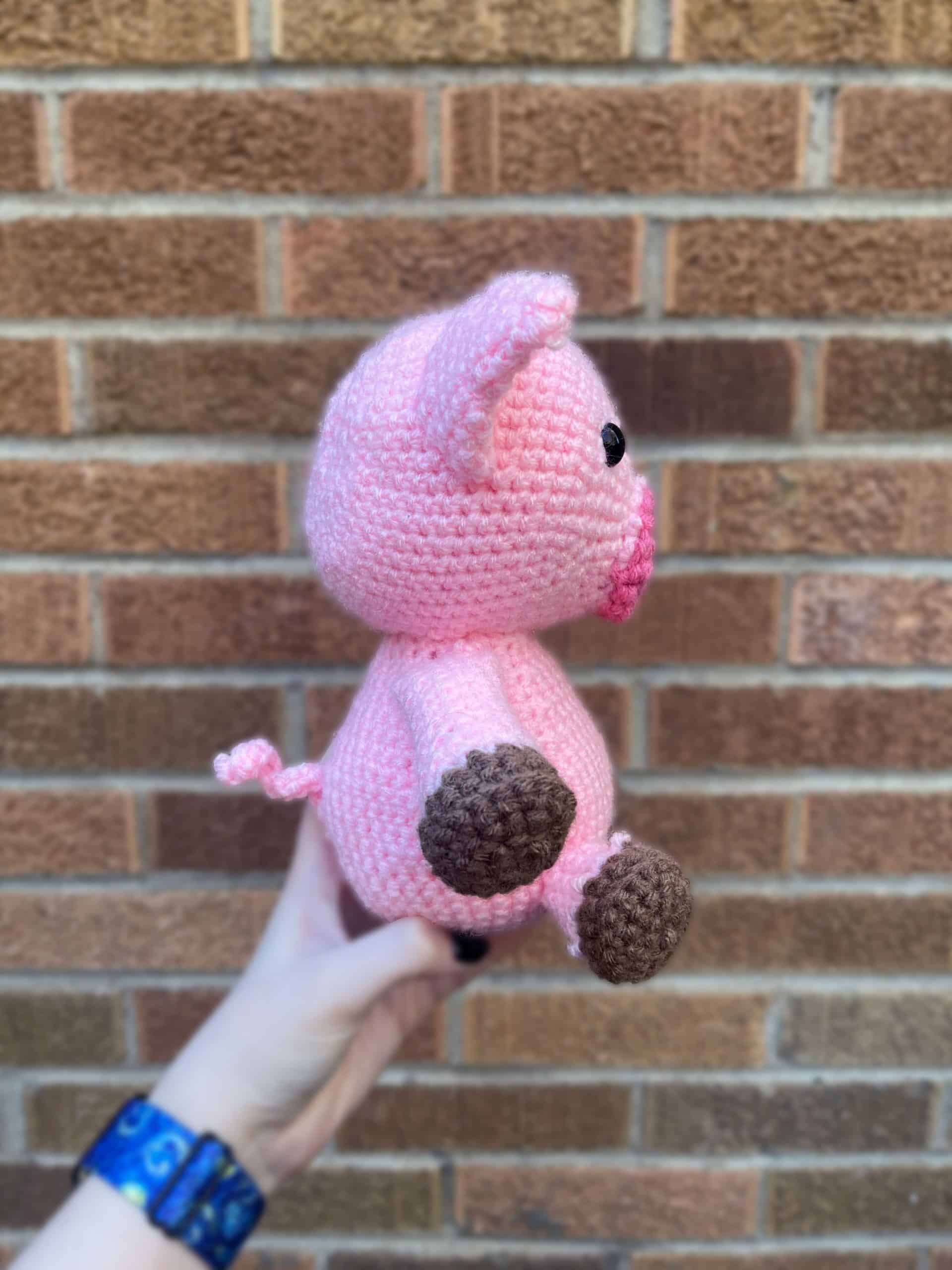 Pink Pig in front of a brick wall right side